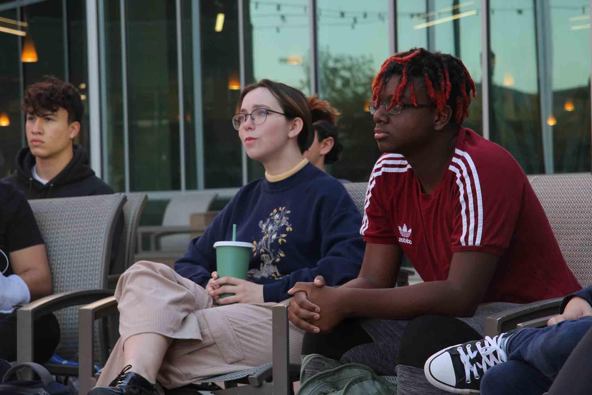 Students sit with attention during an outdoor class session.